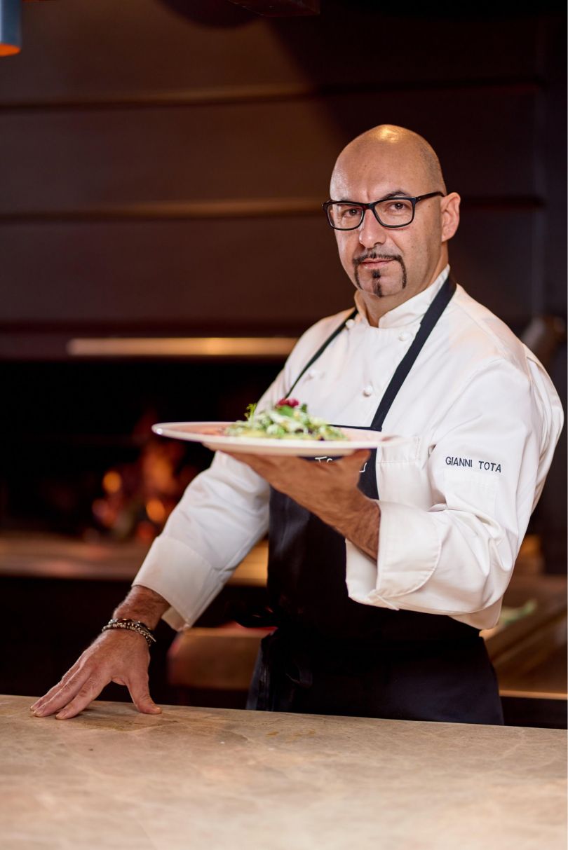 chef holding plate with food
